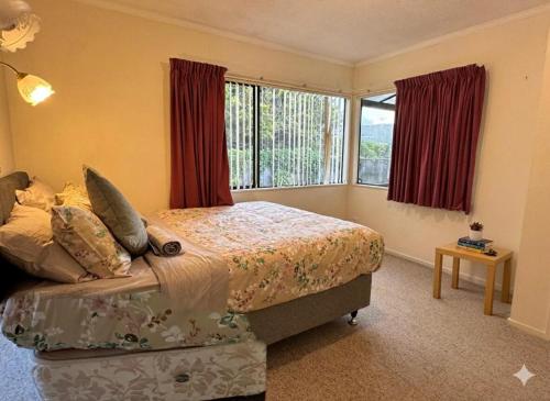 a bedroom with a bed and a large window at Wellington Suburb Stay in Wellington