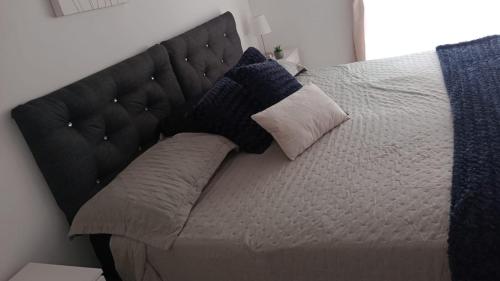 een bed met kussens erop in een slaapkamer bij Hotel Gayra in Antofagasta