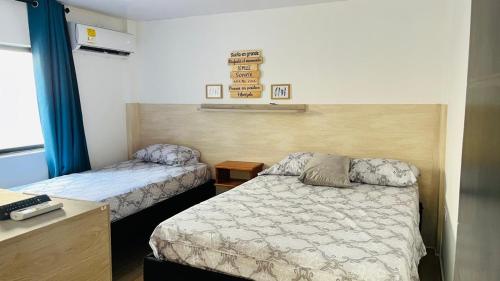 a bedroom with two beds and a desk and a bed sidx sidx sidx at Posada Kotnat in San Andrés