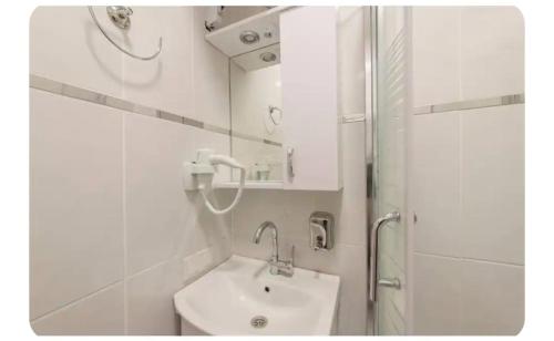 een witte badkamer met een wastafel en een douche bij Sultanahmet Center View Apart Hotel in Istanbul