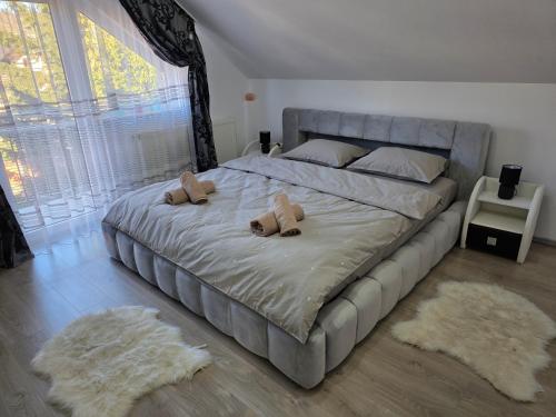 a bedroom with a large bed with two teddy bears on it at Mountain View Apartment in Zărneşti