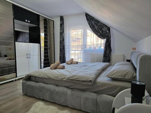 een slaapkamer met een groot bed met twee teddyberen erop bij Mountain View Apartment in Zărneşti