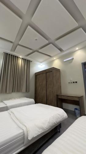 a bedroom with two beds and a ceiling at شاليه ريفالا الفاخر in Abha