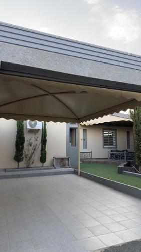 a patio with awning in front of a house at شاليه ريفالا الفاخر in Abha