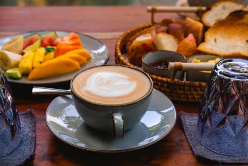 a cup of coffee on a table with a plate of food at BREATHE Collections Habaraduwa in Habaraduwa