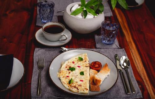 a plate of omelet with toast and a cup of coffee at BREATHE Collections Habaraduwa in Habaraduwa
