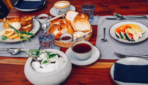 a table with plates of food and cups of coffee at BREATHE Collections Habaraduwa in Habaraduwa