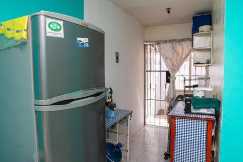een keuken met een koelkast in de hoek van een kamer bij Comfortable and quiet with a pool in Barrio Nuevo