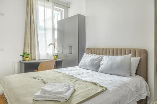 une chambre avec un lit blanc avec un bureau et une fenêtre dans l'établissement Modern Studios near Trent Bridge & City Ground, à Nottingham