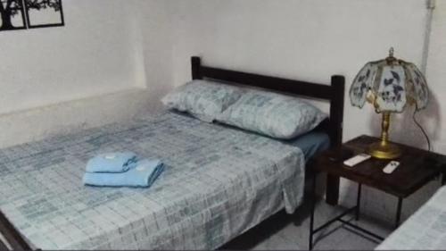 a bedroom with a bed and a table with a lamp at Ruma in Bella Unión