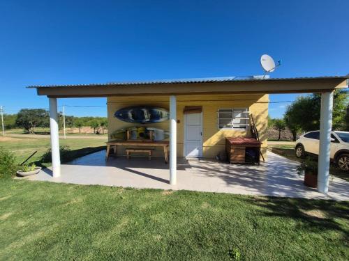een overdekt terras met een auto geparkeerd in een veld. bij Cabaña en Ibicuy in Ibicuy