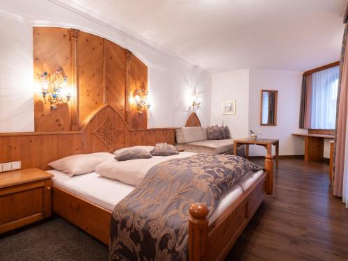 a bedroom with a large bed with a wooden headboard at Hotel Garni Castel B&B in Ischgl