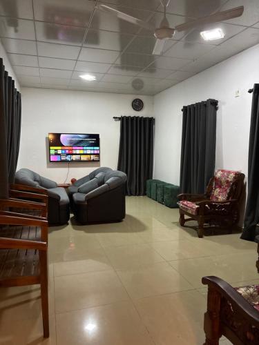 a living room with couches and a flat screen tv at lakshi's place in Ambalangoda