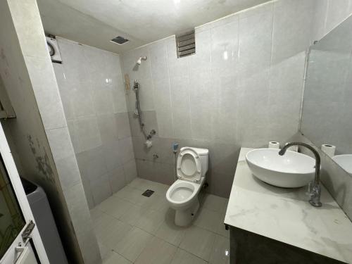 a white bathroom with a sink and a toilet at lakshi's place in Ambalangoda
