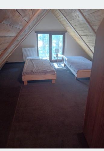 a bedroom with two beds in a attic at Domek letniskowy u Doroty in Walne