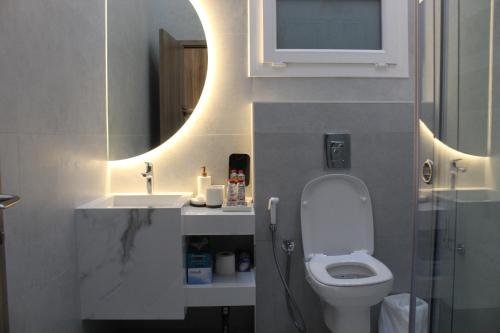 een badkamer met een toilet, een wastafel en een spiegel bij Masfout Mountains View in Sinādil
