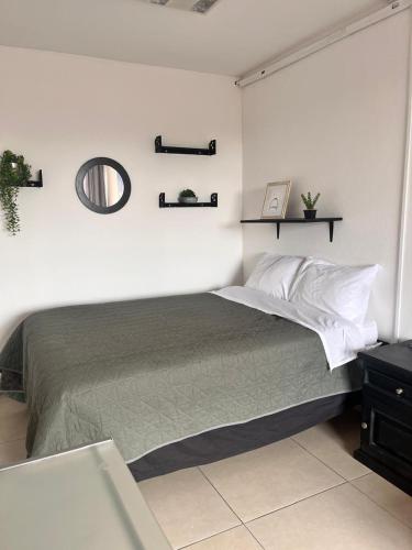 ein Schlafzimmer mit einem Bett und einem Spiegel an der Wand in der Unterkunft Lindo y comodo Loft in Hércules