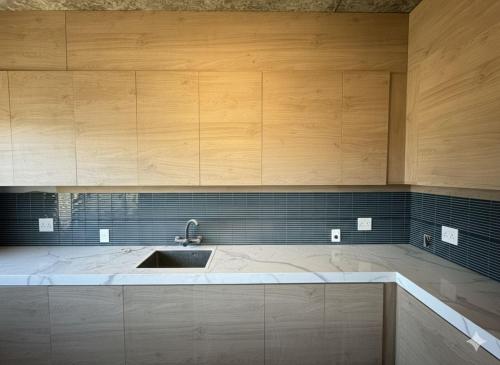 a kitchen with a sink and wooden cabinets at Casa mansa hostel in Maldonado