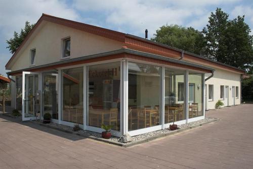 a building with a conservatory with tables and chairs at Eckotel H1 in Eckernförde