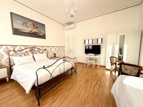 una camera da letto con un letto e una televisione di Negrar Cuore Rooms a Negrar