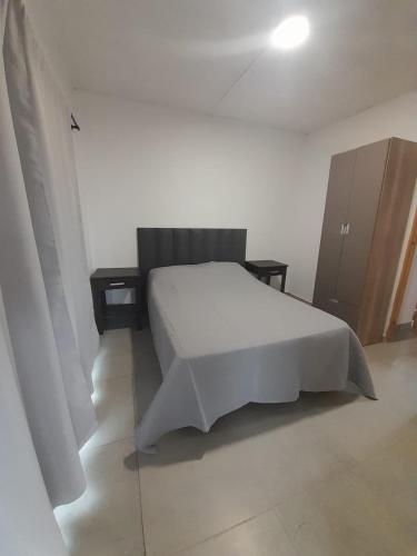 a bedroom with a white bed and two night stands at Casa Aramí in Victoria