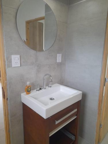 a bathroom with a white sink and a mirror at Casa Aramí in Victoria