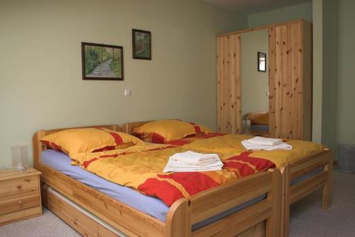 a bedroom with a large bed with yellow and red sheets at Eckotel H1 in Eckernförde