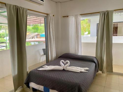 a room with a bed with a bow on it at Hostería "El Paraíso" in Montañita