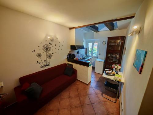 een woonkamer met een rode bank en een keuken bij CASA VACANZA Emma in Monfalcone