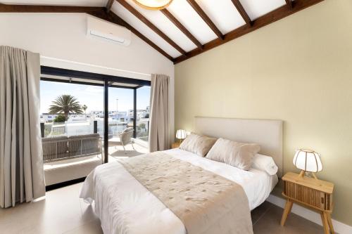 a bedroom with a large bed and a large window at Villa Sara-Princesa Ico in Tías