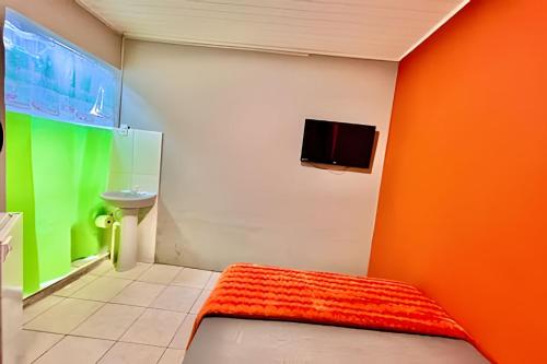 una camera da letto con parete arancione e verde di Pousada Meu Cantinho a Matinhos