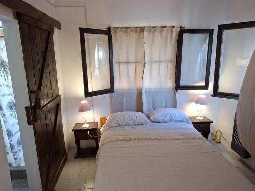 una camera da letto con un letto con due lampade su due tavoli di La mary a Villa Gesell