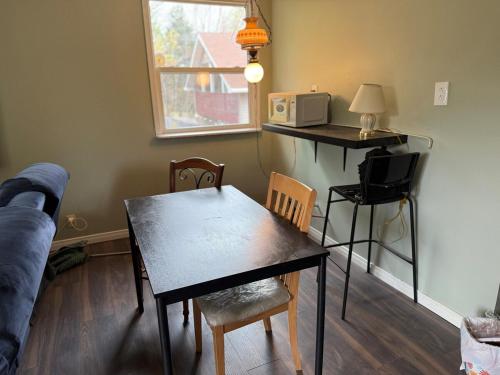 een woonkamer met een tafel en een magnetron bij A fully self-contained one-bedroom apartment in Fredericton