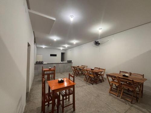 een eetkamer met houten tafels en stoelen bij Pousada Lua Bela in Piranhas