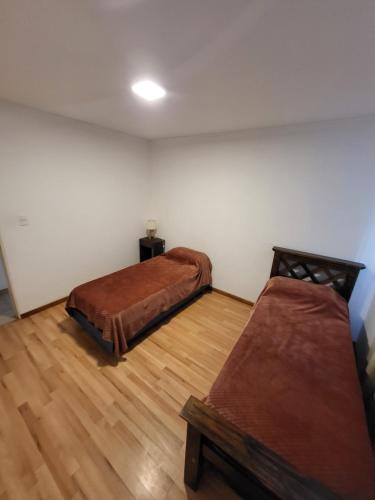 ein Zimmer mit zwei Betten und Holzboden in der Unterkunft Lamorit in Almafuerte