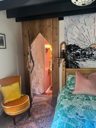 a bedroom with a bed and a chair at Lofthouse - secluded quirky cottage with sea views! in Newport