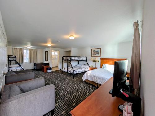 een hotelkamer met een bed, een bank en een tv bij Ponderosa Motel in Goldendale