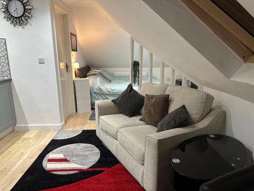 a living room with a couch and a bedroom at A Cosy and Luxurious Studioflat in Navestock