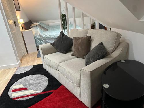 a living room with a couch with pillows on it at A Cosy and Luxurious Studioflat in Navestock