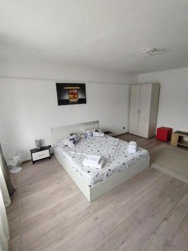 ein Schlafzimmer mit einem Bett in der Mitte eines Zimmers in der Unterkunft Apartament Alessi Home in Călimăneşti