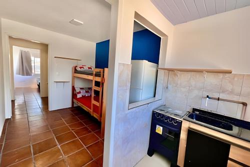 a kitchen with blue cabinets and a stove top oven at BriSa Do Mar < Flecta Matinhos in Matinhos