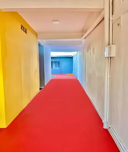 a red carpet corridor with a red carpet at BriSa Do Mar < Flecta Matinhos in Matinhos