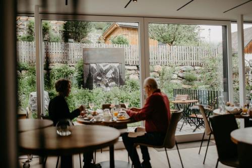 twee mensen aan tafel in een restaurant bij Mesnerhaus & Gourmetrestaurant Mesnerhaus mit 4 Hauben in Mauterndorf