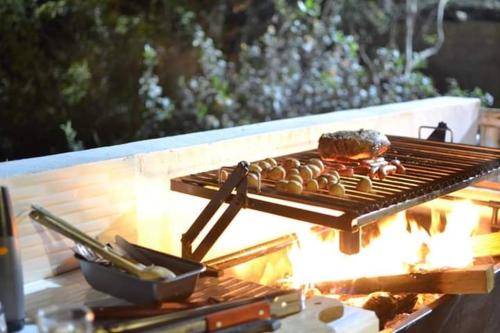 una griglia con un hamburger e del cibo sopra di San Jerónimo River Lodge a Lunahuaná