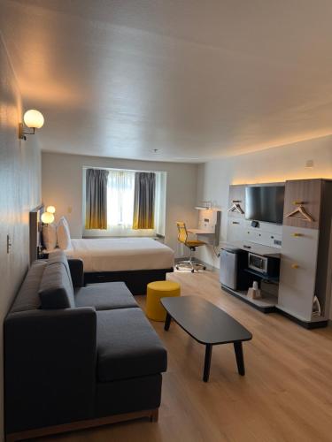 a living room with a couch and a bed in a room at Microtel Inn and Suites Baton Rouge Airport in Baton Rouge