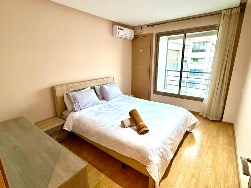a bedroom with a bed with a large window at Appartement avec vue sur parc et Wifi 100 Mo illimité ! in Fez