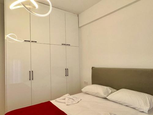 a bedroom with white cabinets and a bed with a red blanket at VASKO Luxury Suites 4 in Siátista