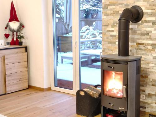 ein Holzofen im Wohnzimmer neben einer Tür in der Unterkunft Gemütliches Haus mit Schwedenofen im Wienerwald in Neulengbach