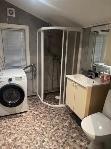 a bathroom with a washing machine and a sink at Øse Camping in Gratangen