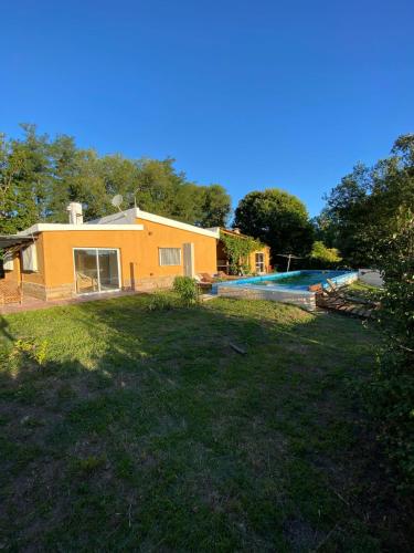 een huis met een tuin en een zwembad bij Villa Messina, Casa di Vacanza in Juana Koslay 